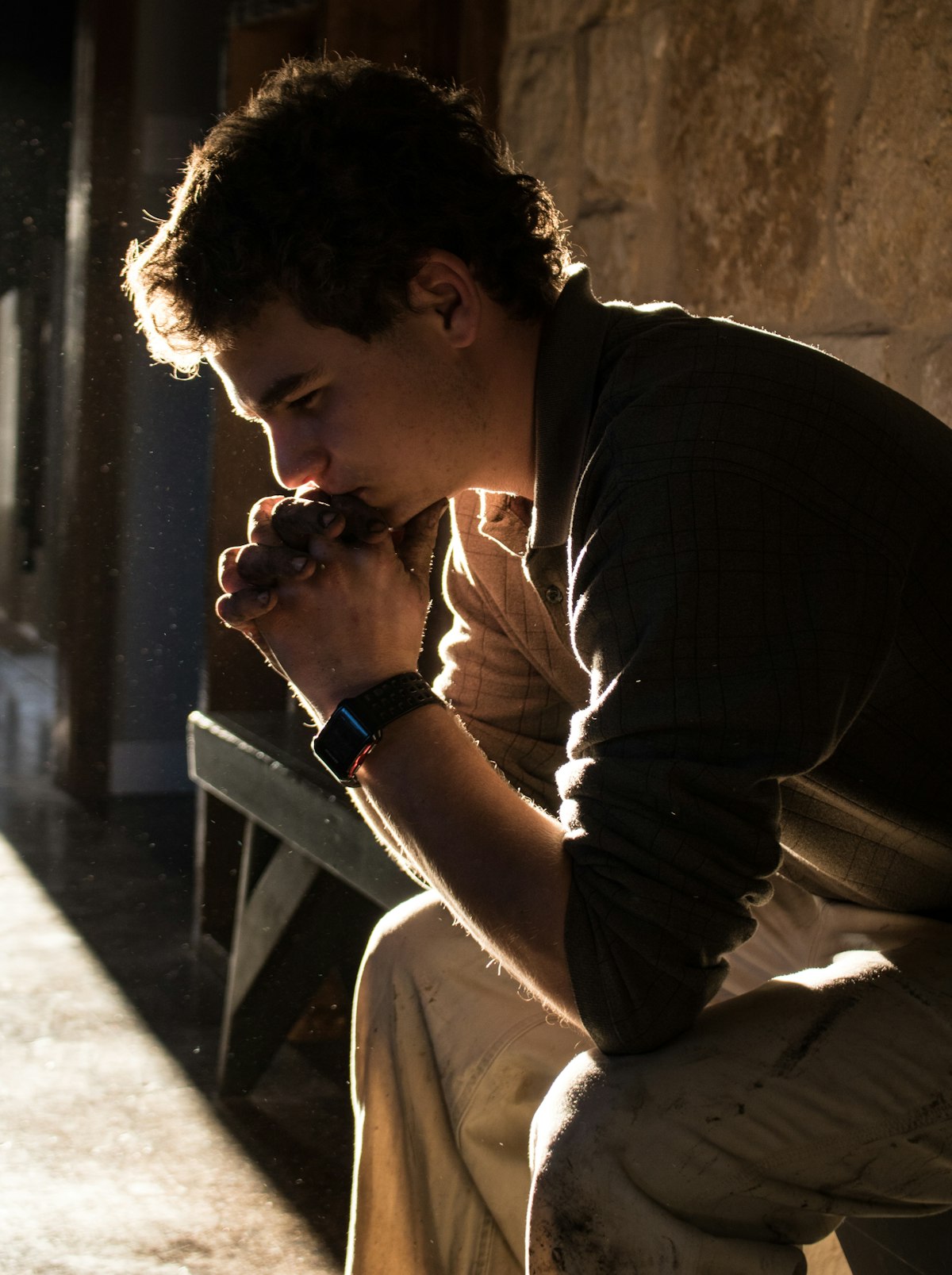 ベンチに座って考え事をする男性のシルエット