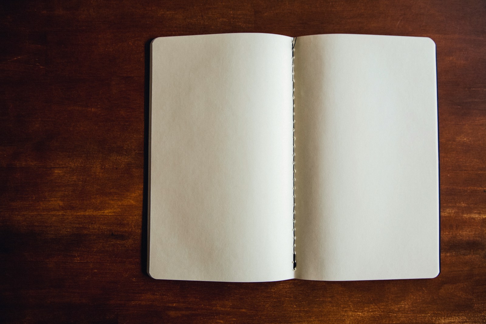 木の机の上で開かれた、何も書かれていないノート